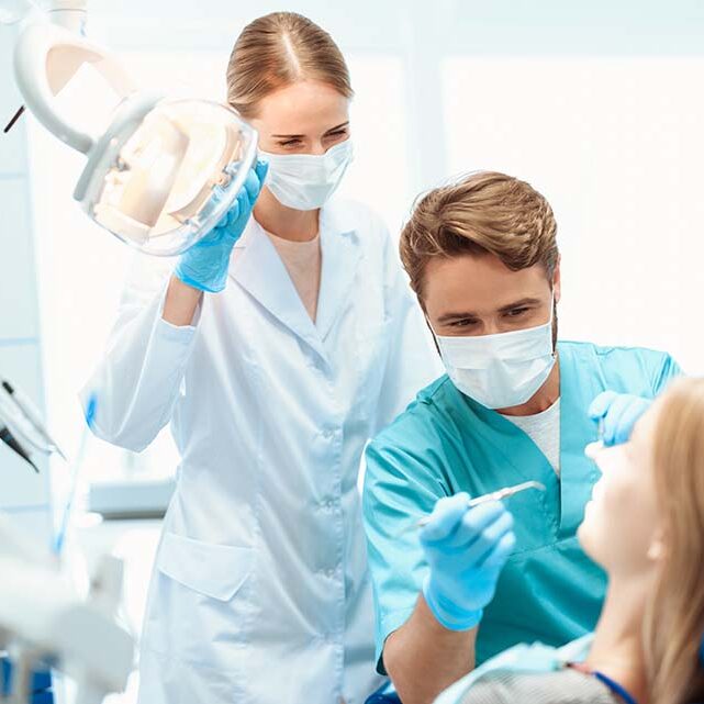 dentist-nurse-treat-patient-dental-office dentist-nurse-treat-patient-dental-office