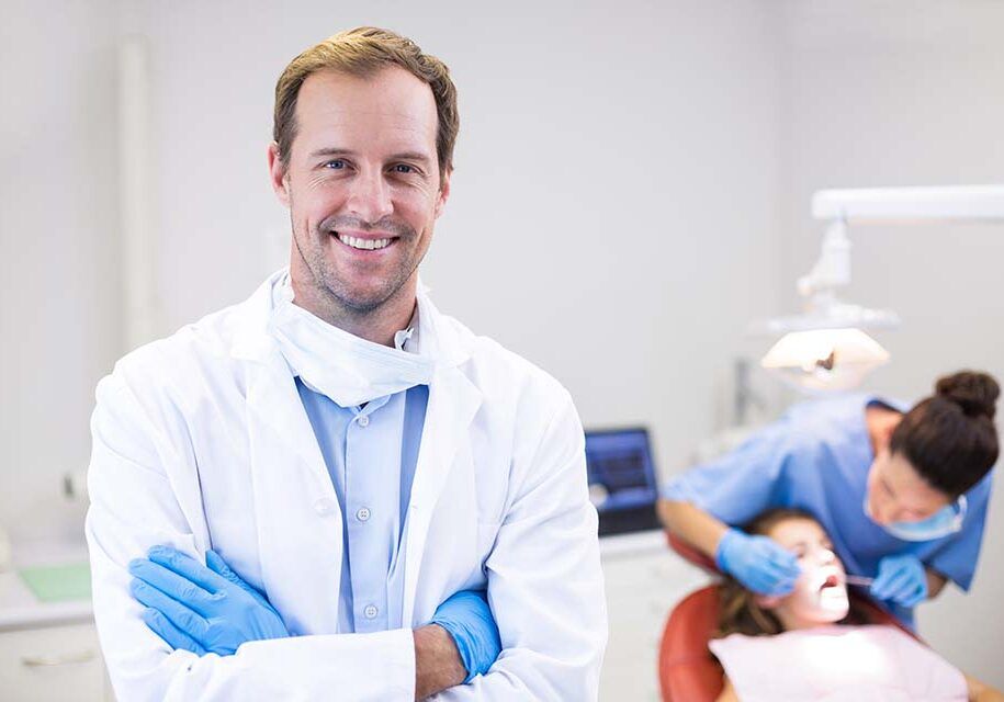 dentist-standing-with-arms-crossed-clinic